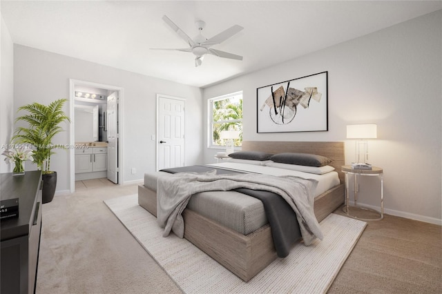 bedroom with ceiling fan, baseboards, ensuite bathroom, and light carpet