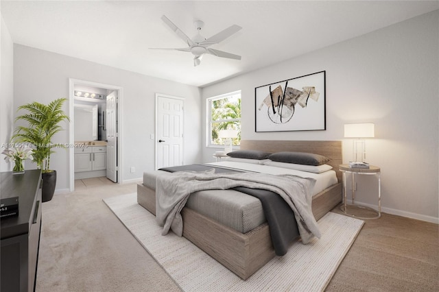 bedroom with ceiling fan, baseboards, light carpet, and ensuite bathroom