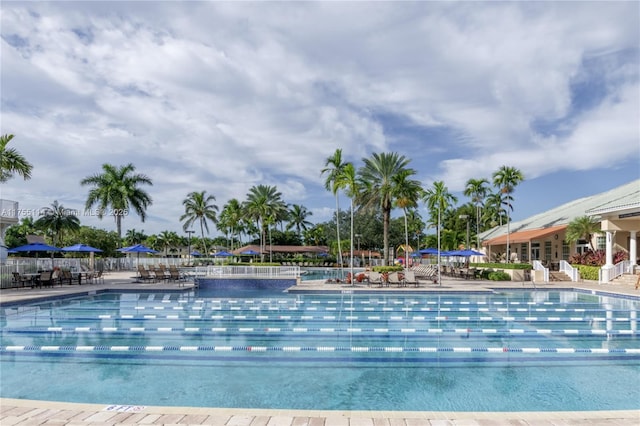 community pool with a patio and fence