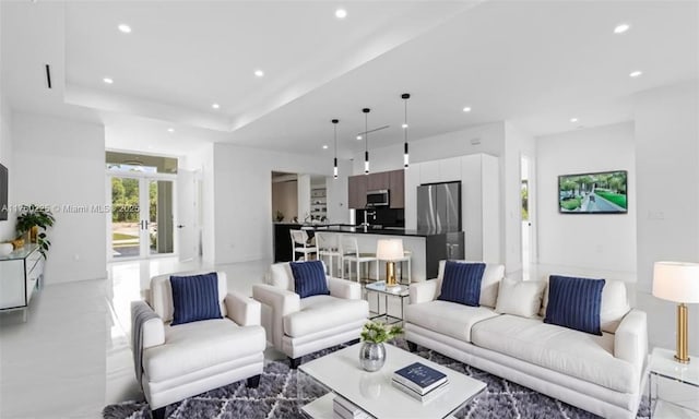 living area with recessed lighting and a raised ceiling