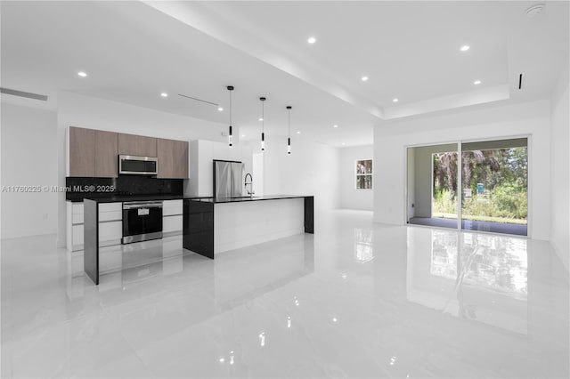 kitchen featuring visible vents, stainless steel appliances, dark countertops, modern cabinets, and open floor plan