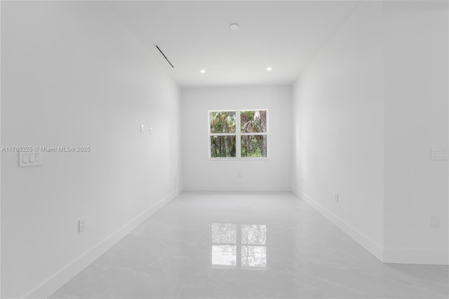 spare room featuring recessed lighting, baseboards, and concrete flooring