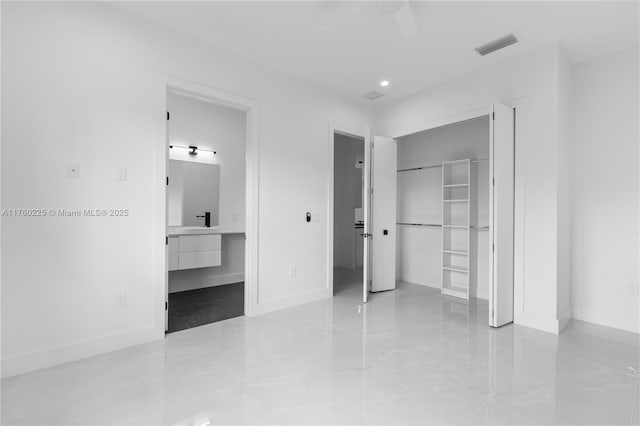 unfurnished bedroom featuring visible vents, baseboards, a closet, and connected bathroom