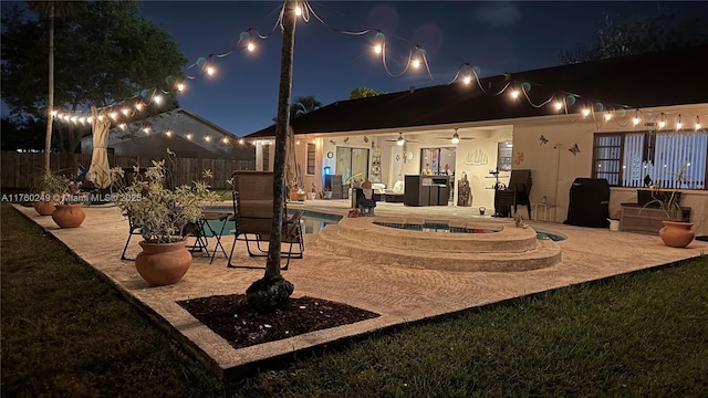 patio at twilight with fence and a fenced in pool