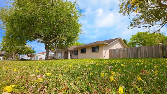 view of front of house featuring fence and stucco siding