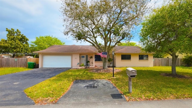 single story home with an attached garage, driveway, a front lawn, and fence