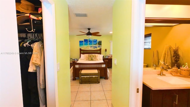 bathroom featuring tile patterned flooring, visible vents, a spacious closet, ceiling fan, and vanity