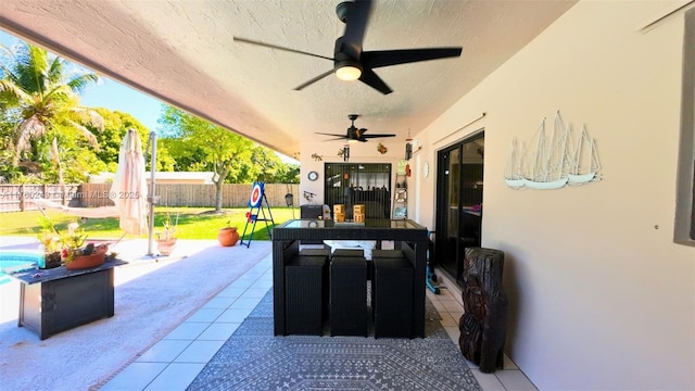 view of patio featuring ceiling fan and fence