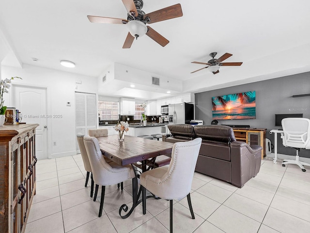 dining room featuring light tile patterned flooring, visible vents, and baseboards