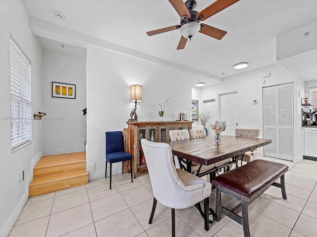 dining area featuring light tile patterned floors, baseboards, and ceiling fan