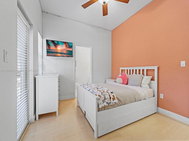 bedroom with light wood-style flooring, baseboards, and ceiling fan