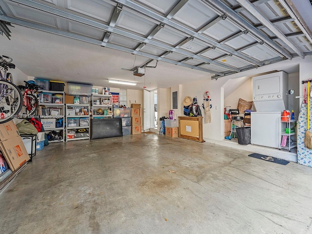 garage with stacked washer / dryer and a garage door opener