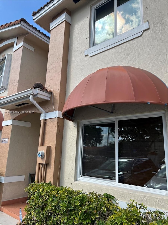 exterior space featuring electric meter and stucco siding