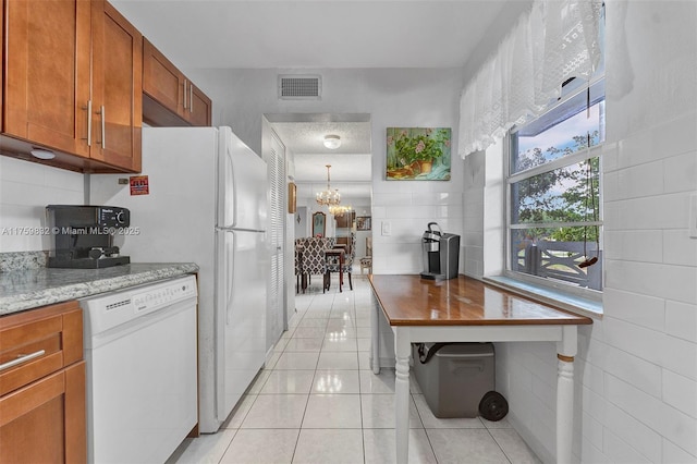 kitchen featuring dishwasher, light tile patterned floors, visible vents, and brown cabinets