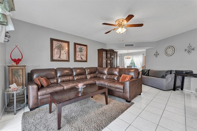 living area featuring light tile patterned floors, visible vents, ceiling fan with notable chandelier, and a textured ceiling