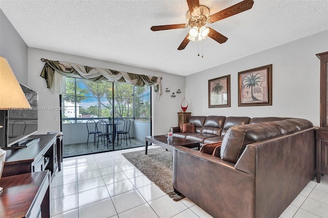 living room with ceiling fan, light tile patterned floors, and a textured ceiling