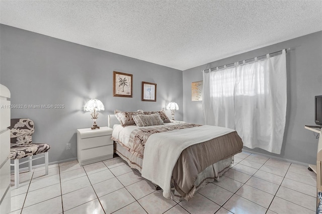 bedroom with light tile patterned floors, baseboards, and a textured ceiling