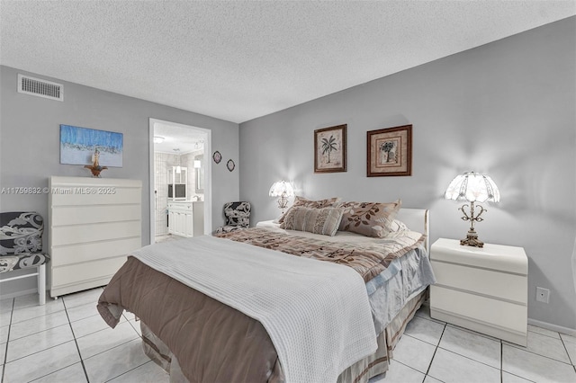 bedroom featuring light tile patterned flooring, visible vents, and a textured ceiling