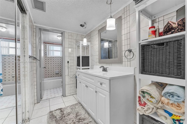 full bath with tile patterned floors, visible vents, a textured ceiling, and tile walls