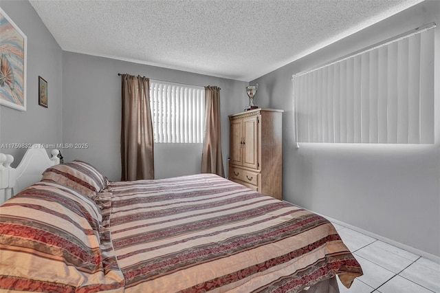 bedroom with light tile patterned floors and a textured ceiling