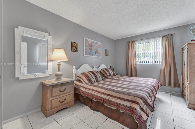 bedroom with light tile patterned floors, baseboards, and a textured ceiling