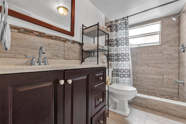 bathroom with toilet, vanity, and a tile shower