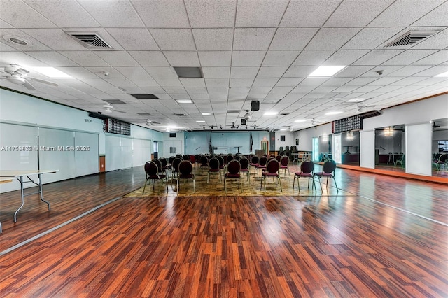 workout area with visible vents, a paneled ceiling, and wood finished floors