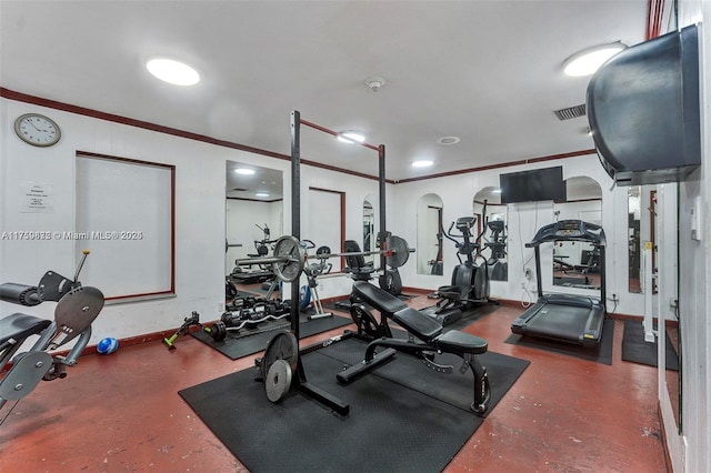 workout area featuring visible vents, crown molding, and baseboards