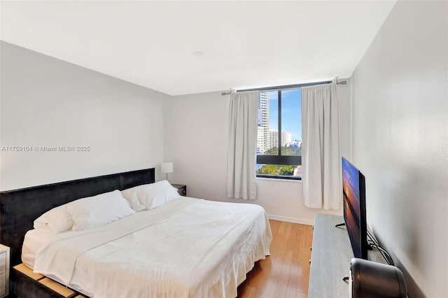 bedroom featuring baseboards and wood finished floors