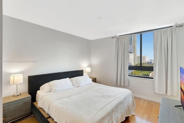 bedroom featuring baseboards and wood finished floors