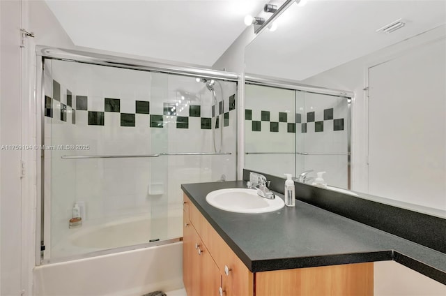 bathroom featuring visible vents, enclosed tub / shower combo, and vanity