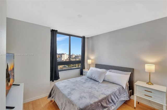 bedroom featuring baseboards and light wood-type flooring