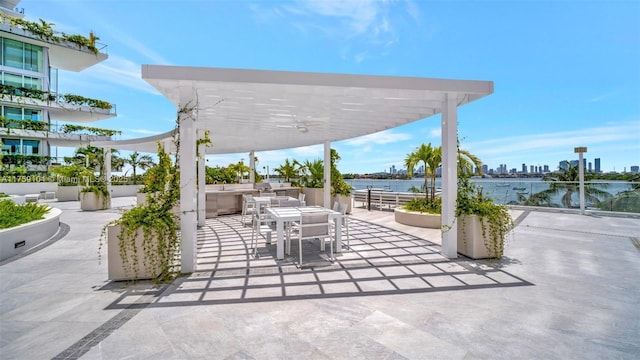 view of patio / terrace with outdoor dining area, a water view, a city view, and a pergola