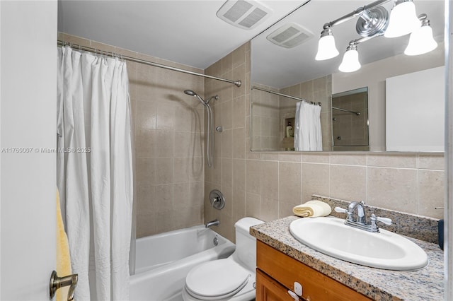 bathroom featuring visible vents, backsplash, tile walls, and shower / bath combo