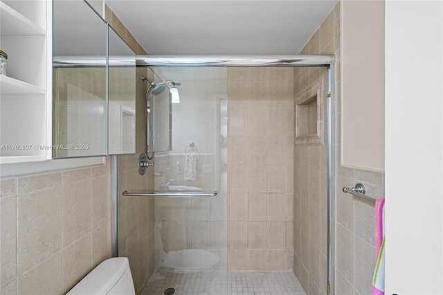 full bathroom featuring a stall shower, toilet, and tile walls