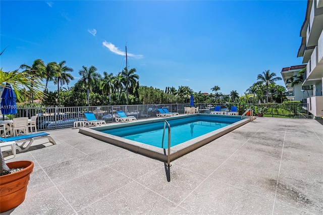 community pool with a patio and fence