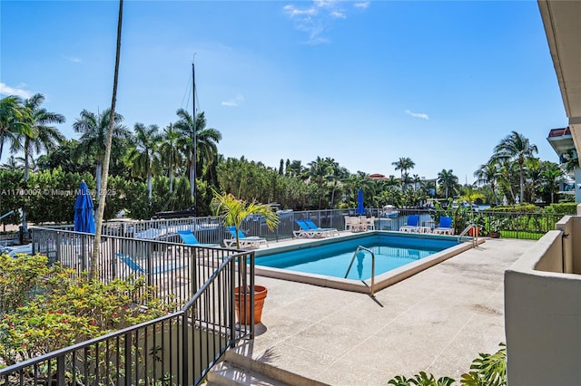 pool with a patio and fence