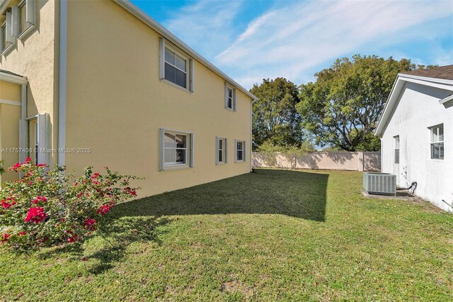 view of yard featuring central AC unit and fence