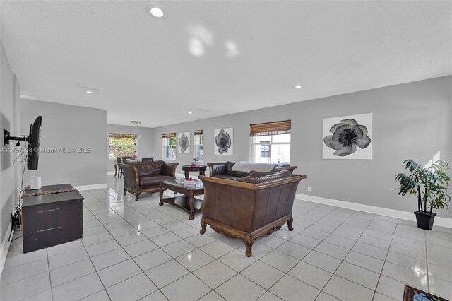 living room featuring baseboards, a healthy amount of sunlight, and light tile patterned flooring