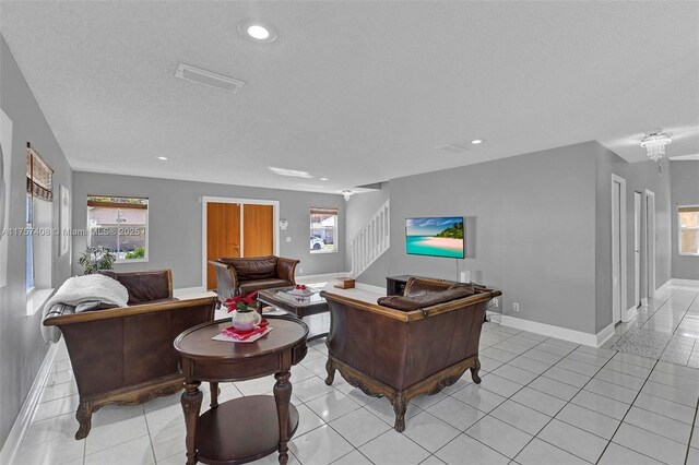 living room featuring stairway, light tile patterned floors, and a healthy amount of sunlight