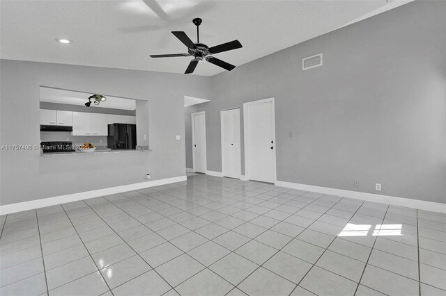 unfurnished living room featuring light tile patterned floors, baseboards, visible vents, lofted ceiling, and ceiling fan