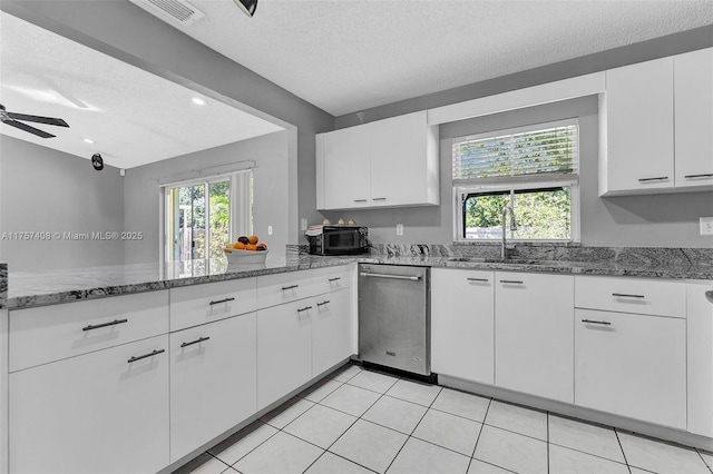 kitchen with dishwasher, white cabinetry, a textured ceiling, and a sink