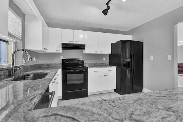 kitchen with light stone counters, a sink, black appliances, under cabinet range hood, and white cabinetry