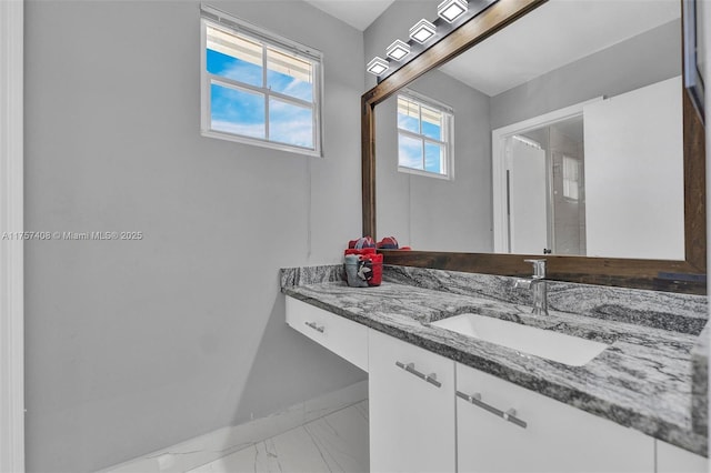 bathroom with vanity, baseboards, and marble finish floor