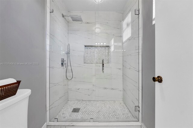 bathroom featuring toilet and a marble finish shower