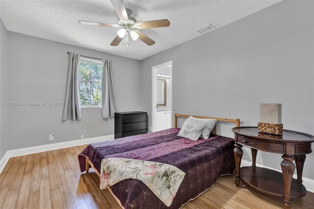 bedroom with visible vents, baseboards, and wood finished floors