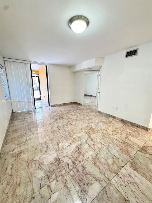 unfurnished room with visible vents, marble finish floor, and baseboards