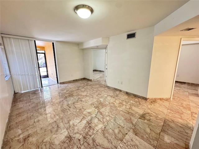 empty room with visible vents, baseboards, and marble finish floor