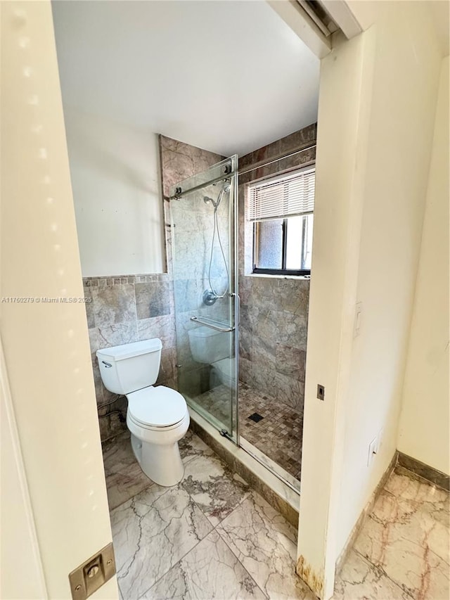 full bathroom with marble finish floor, toilet, and a shower stall