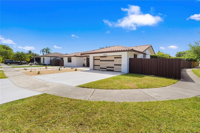 view of front facade with stucco siding, fence, concrete driveway, a garage, and a tiled roof